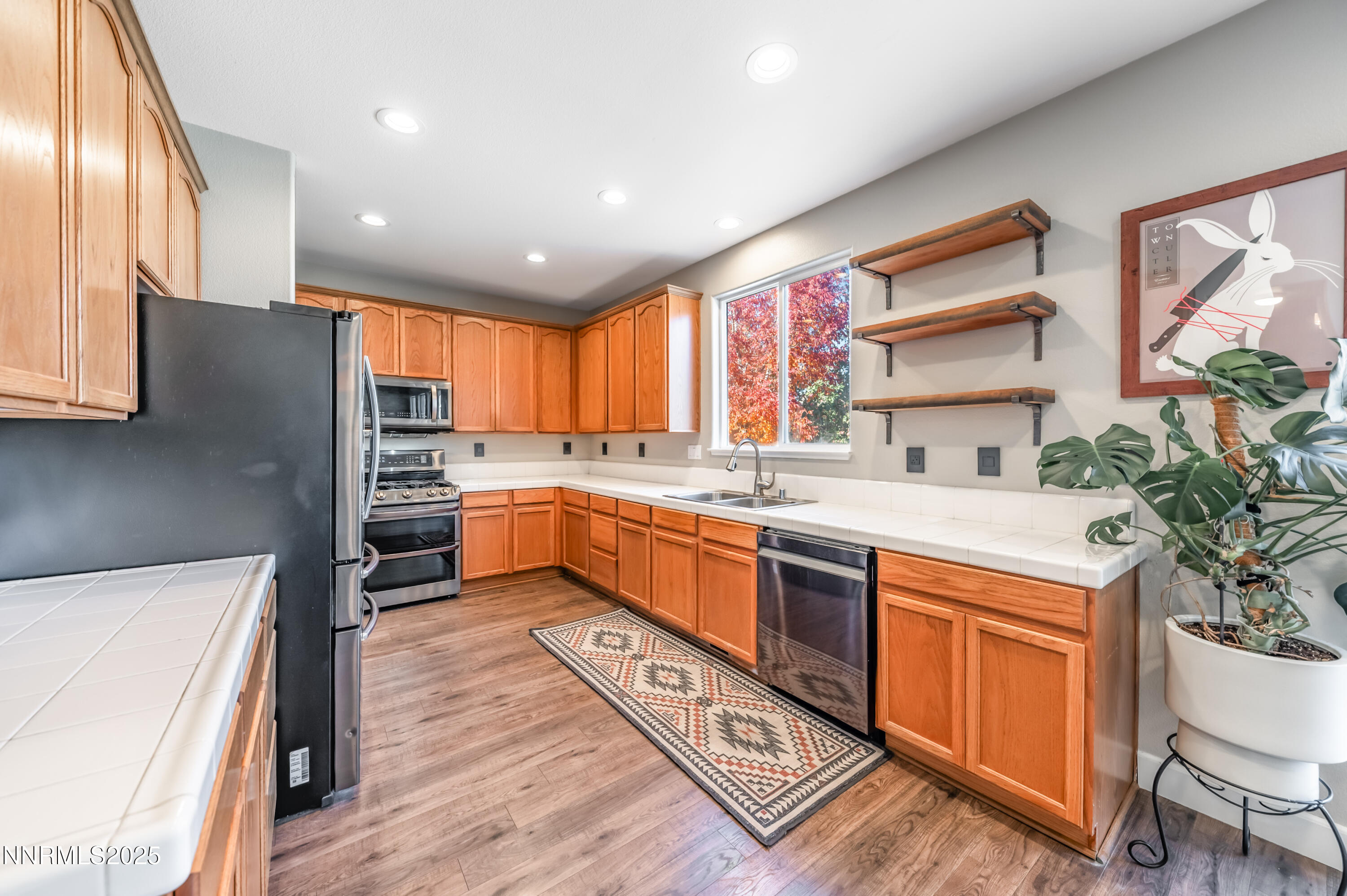 1770 Kodiak Circle Reno, NV 89511 - Photo 10 of 29 a kitchen with stainless steel appliances kitchen island granite countertop a stove a sink and a refrigerator