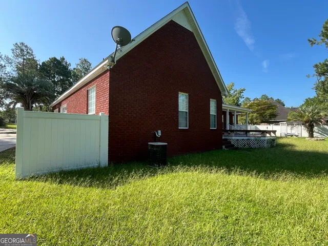 an empty room with wooden floor chandelier fan and windows
