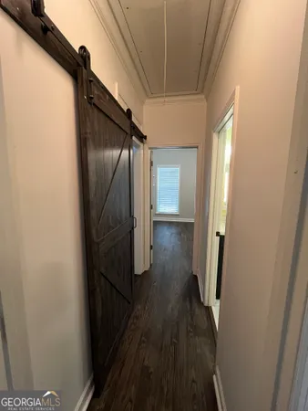 an empty room with wooden floor fan and window