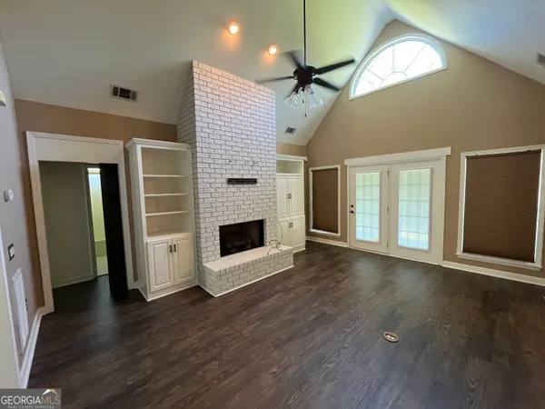 a view of an empty room with wooden floor