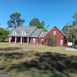 a front view of a house with a garden and yard