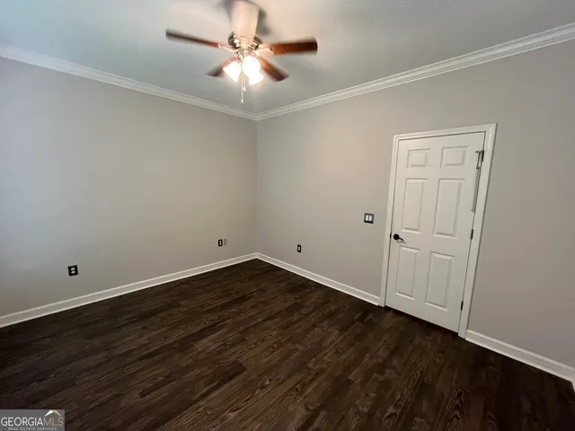 an empty room with a window and a chandelier fan