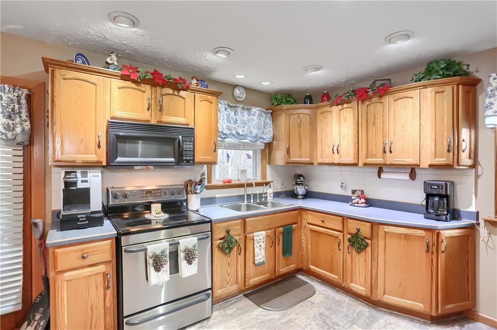 154 Weinschenk Road New Castle, PA 16101 - Photo 13 of 21 a kitchen with granite countertop a sink stainless steel appliances wooden cabinets and a window