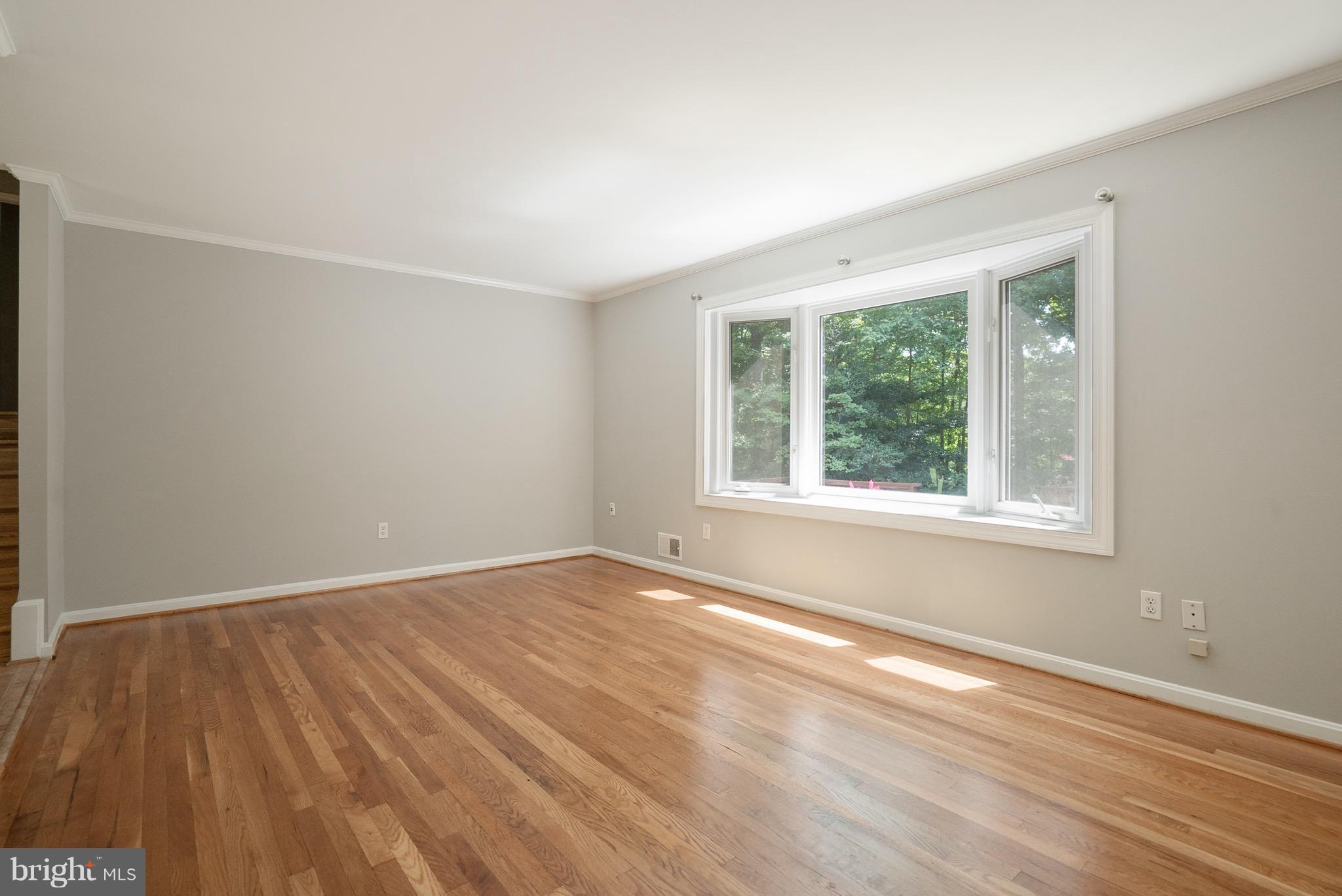 6928 Sydenstricker Road Springfield, VA 22153 - Photo 18 of 30 a view of an empty room with wooden floor and a window