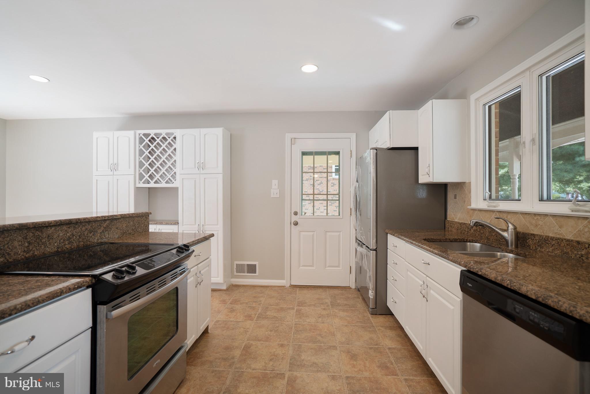 6928 Sydenstricker Road Springfield, VA 22153 - Photo 6 of 30 a kitchen with stainless steel appliances granite countertop a sink stove and refrigerator
