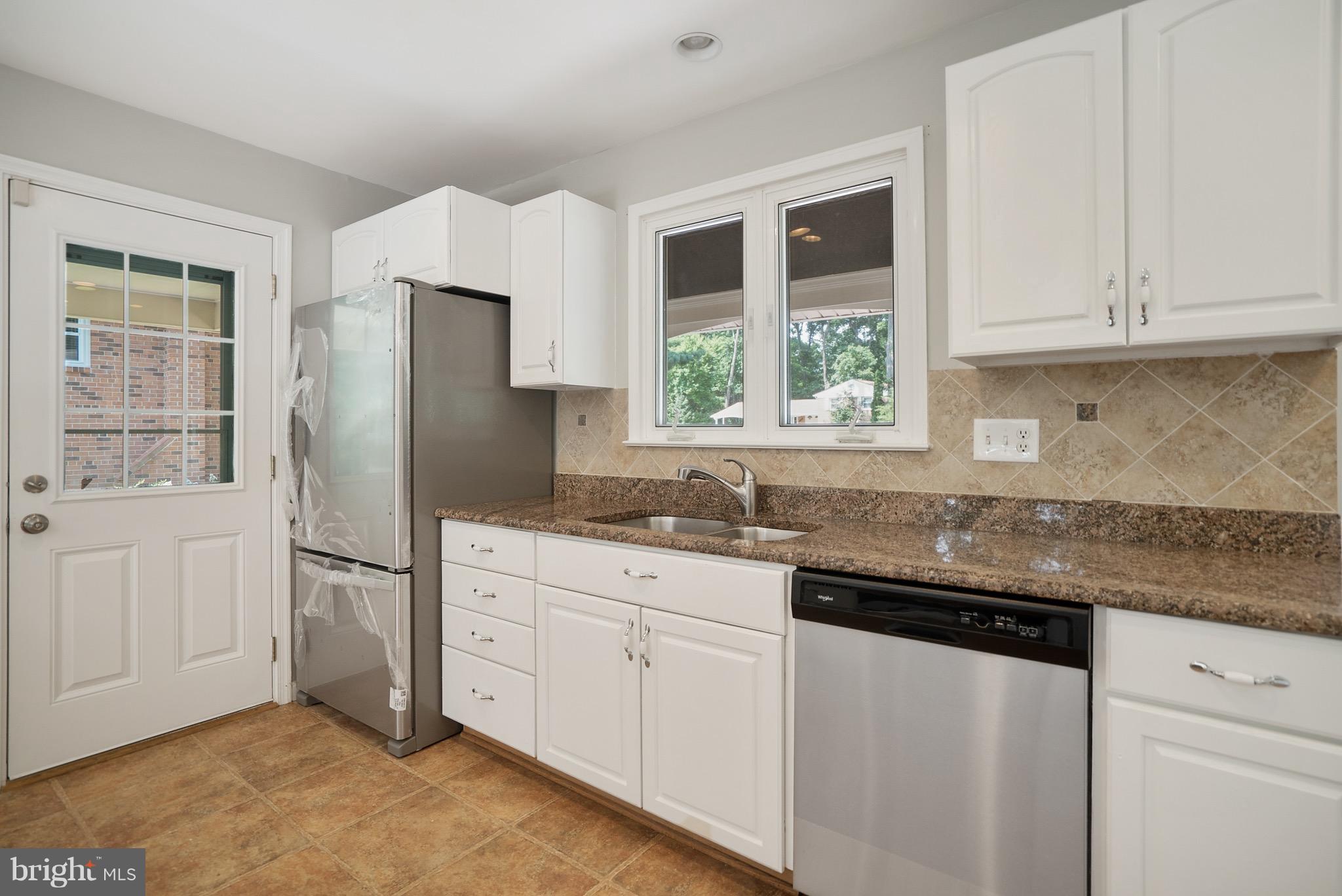 6928 Sydenstricker Road Springfield, VA 22153 - Photo 7 of 30 a kitchen with stainless steel appliances granite countertop a refrigerator sink and cabinets