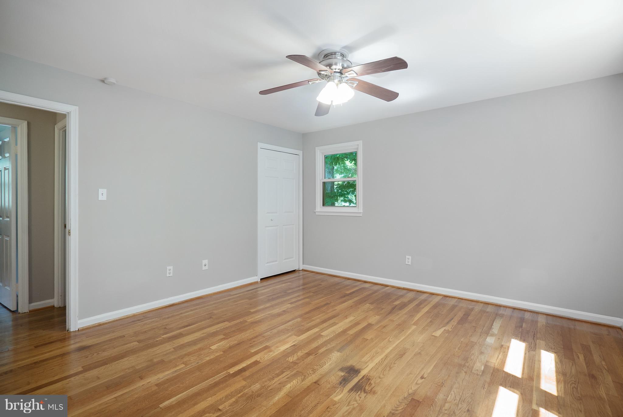 6928 Sydenstricker Road Springfield, VA 22153 - Photo 9 of 30 a view of an empty room with wooden floor and a window
