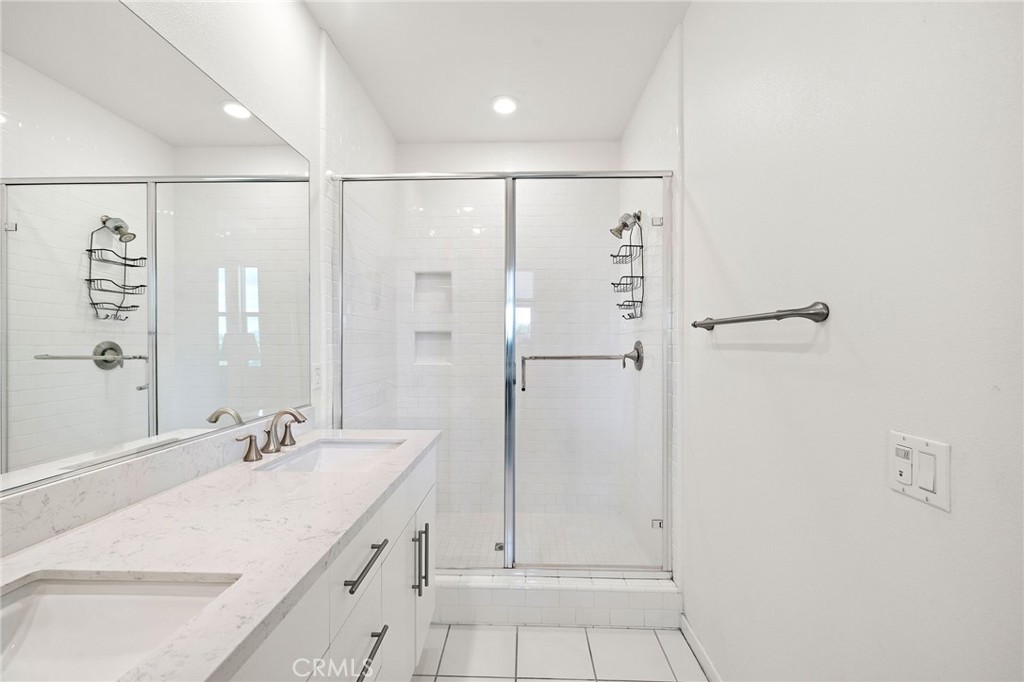 144 Paramount Irvine, CA 92618 - Photo 17 of 43 a bathroom with a granite countertop sink a shower and a mirror