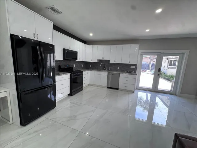a kitchen with stainless steel appliances granite countertop a refrigerator and a stove top oven