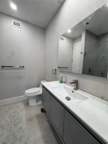 a bathroom with a sink a toilet and mirror