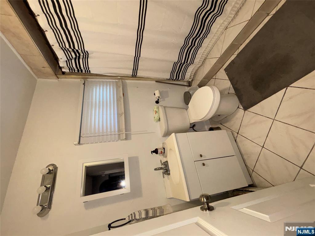 23 Oak Street Paterson, NJ 07501 - Photo 12 of 19 a bathroom with a toilet sink and mirror