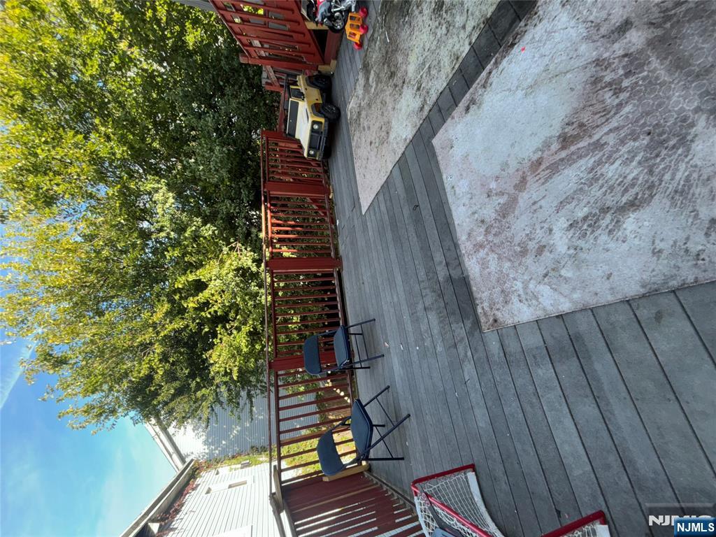 23 Oak Street Paterson, NJ 07501 - Photo 13 of 19 a view of a patio with table and chairs with wooden floor and fence
