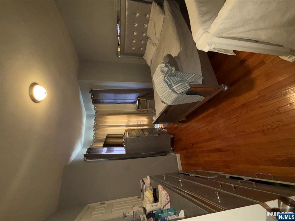 23 Oak Street Paterson, NJ 07501 - Photo 10 of 19 a bedroom with a bed and wooden floor