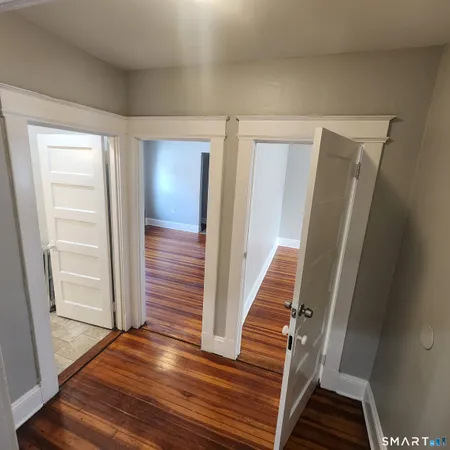 a view of a hallway with wooden floor and staircase