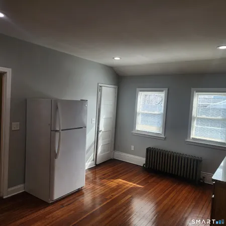 a view of a livingroom with wooden floor and window