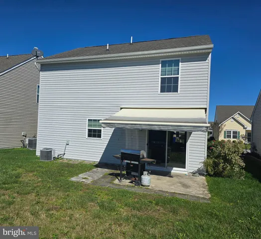 a view of a house with a yard and sitting area