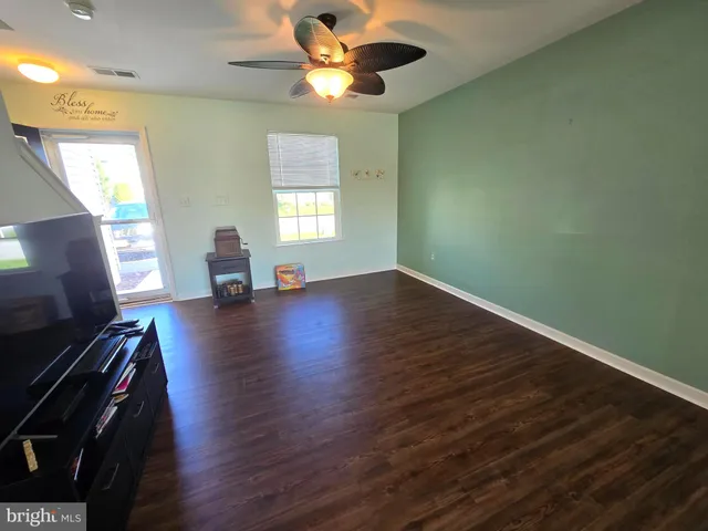 a view of a livingroom with wooden floor and a ceiling fan