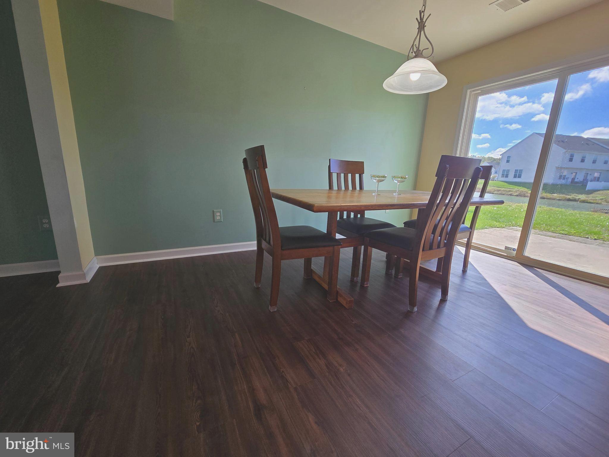 181 Bobbys Branch Road, Unit 35 Millsboro, DE 19966 - Photo 6 of 26 a view of a dining room with furniture wooden floor and chandelier