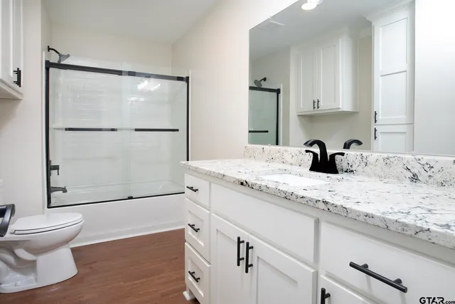 a bathroom with a granite countertop sink toilet and shower