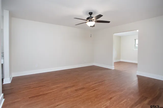 a view of an empty room with wooden floor