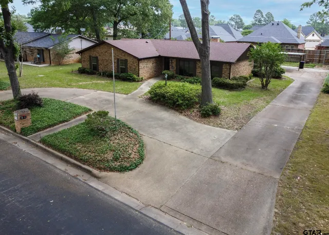 a view of a house with a yard and large tree