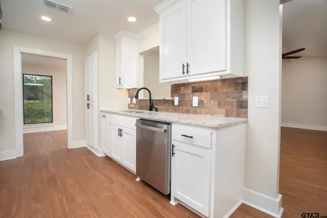 a kitchen with a sink cabinets stainless steel appliances and a window