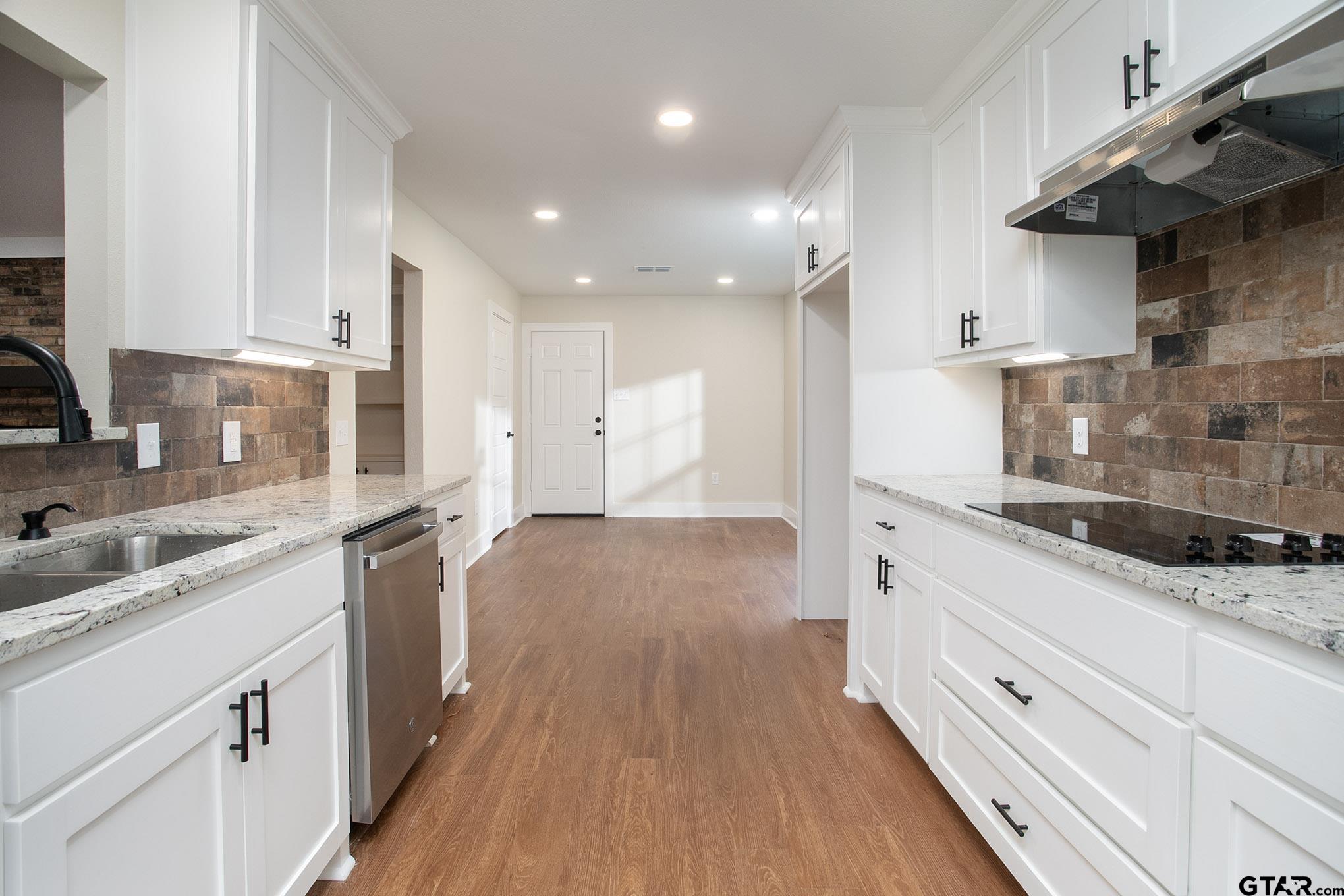 610 Rockwall Drive Longview, TX 75604 - Photo 7 of 39 a kitchen with granite countertop a sink stove and cabinets