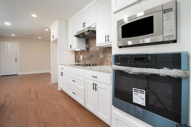 a kitchen with stainless steel appliances kitchen island granite countertop a stove a sink and a microwave