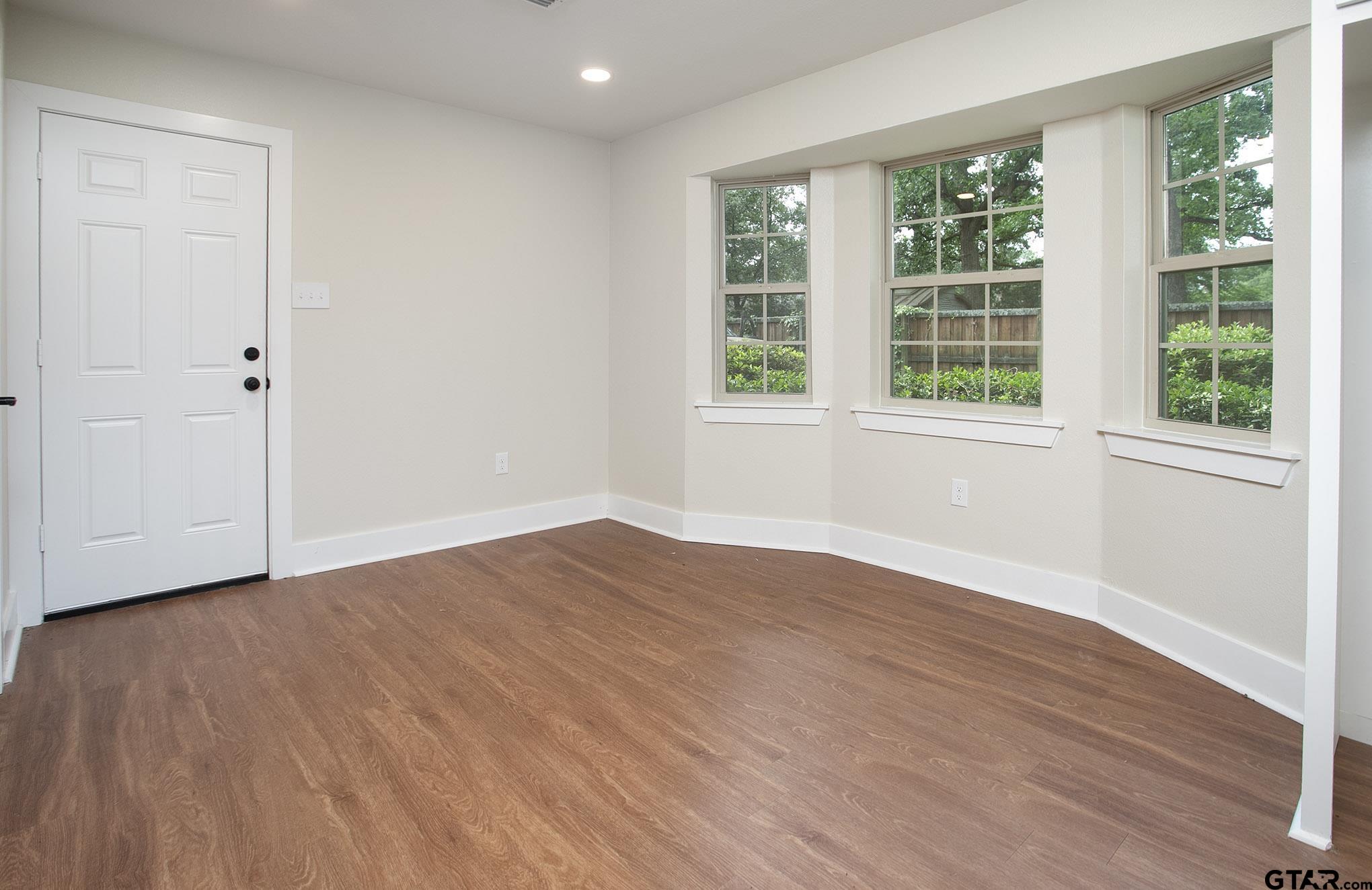 610 Rockwall Drive Longview, TX 75604 - Photo 10 of 39 a view of an empty room with wooden floor and a window