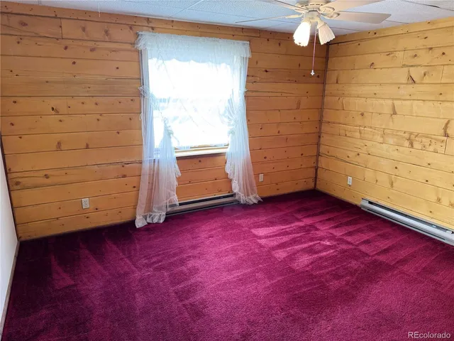 an empty room with a window and wooden floor