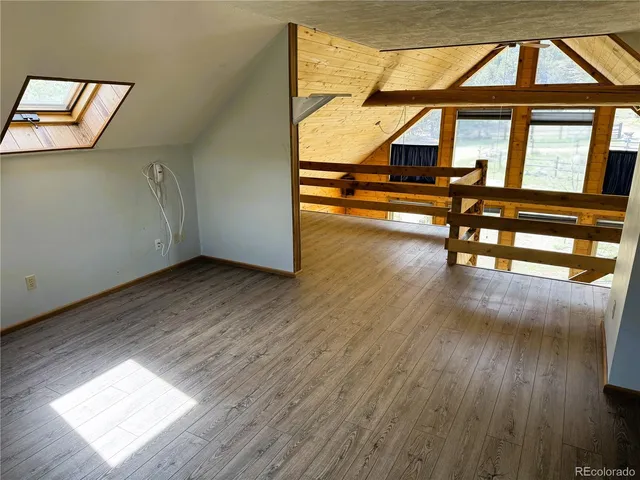 a swimming pool that has lawn chairs and a dining table under an umbrella
