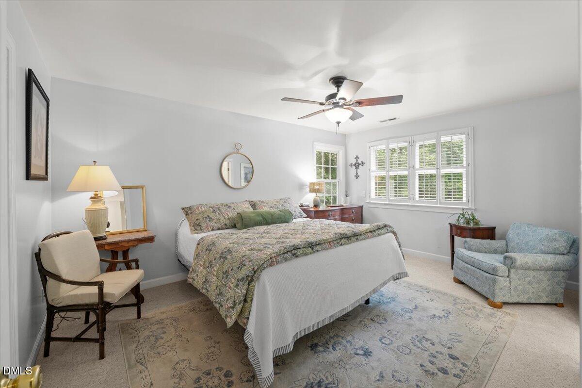 109 Hemingway Forest Place Raleigh, NC 27607 - Photo 16 of 33 a spacious bedroom with a bed a couch and a chandelier