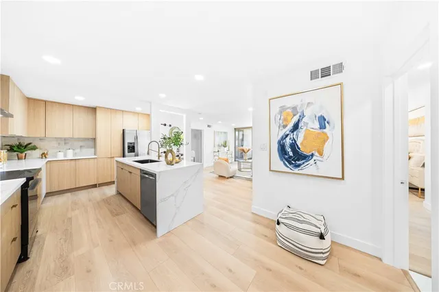 a large white kitchen with stainless steel appliances granite countertop a stove and a cabinets