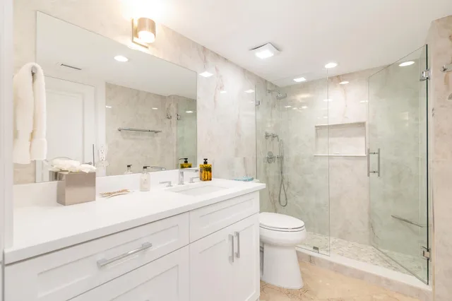 a bathroom with a sink a toilet and shower