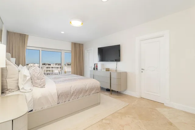 a bedroom with a bed and a flat tv screen on wall