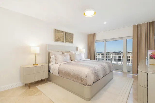 a spacious bedroom with a bed and a lamp