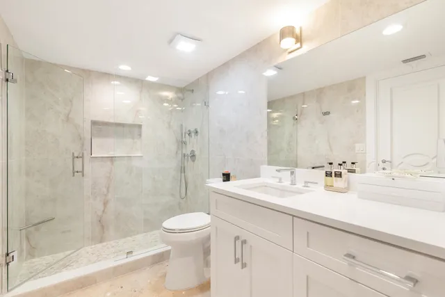 a bathroom with a sink a toilet and shower