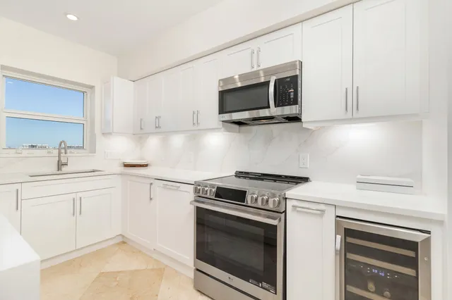 a kitchen with white cabinets and stainless steel appliances