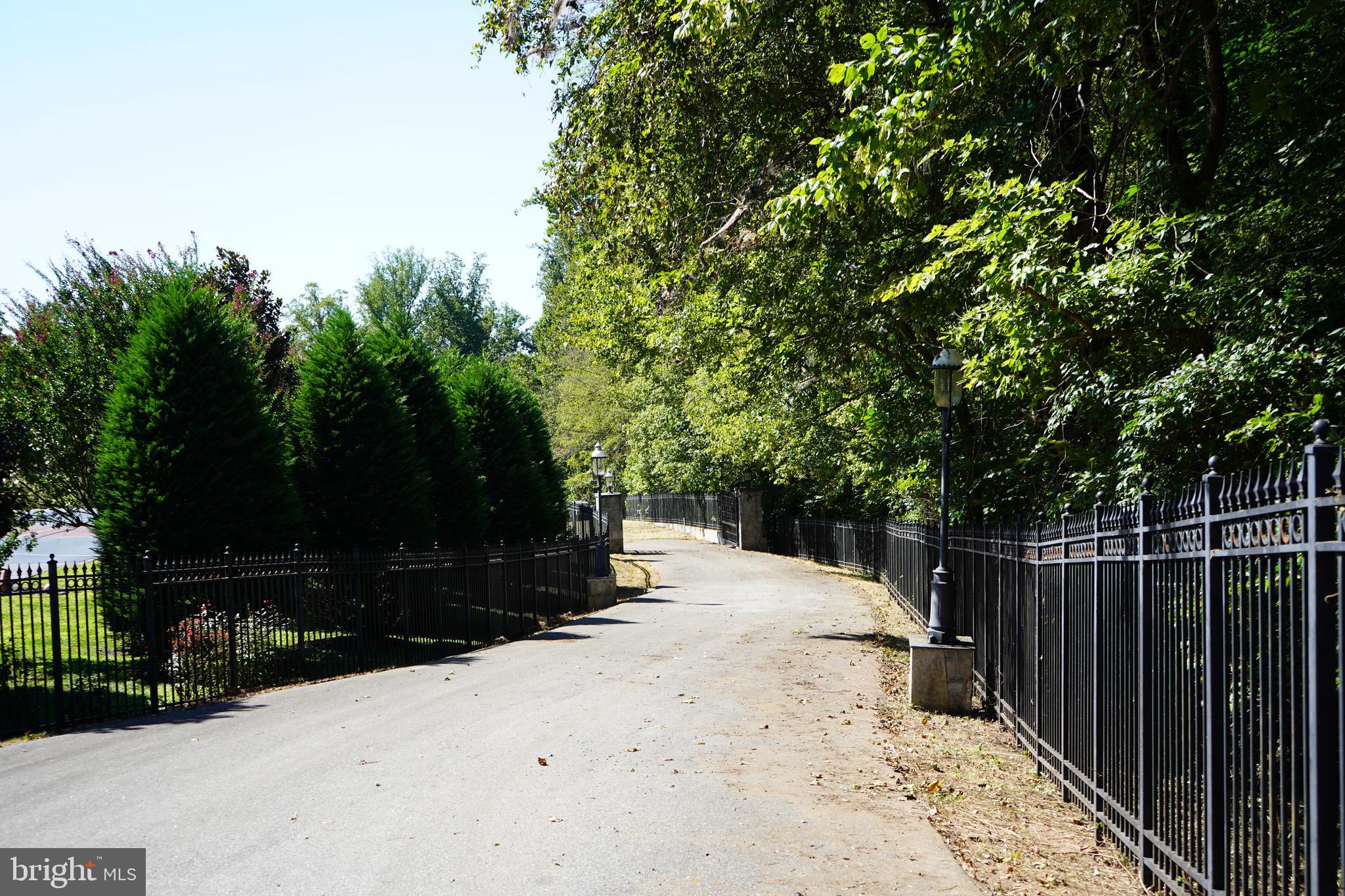12000 River Road Potomac, MD 20854 - Photo 6 of 13 a street view with wooden fence and trees