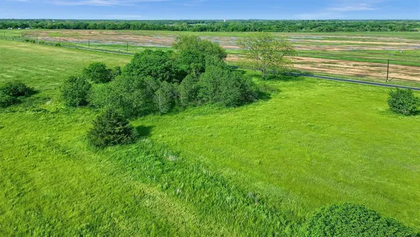 a view of a lake with a yard and large trees
