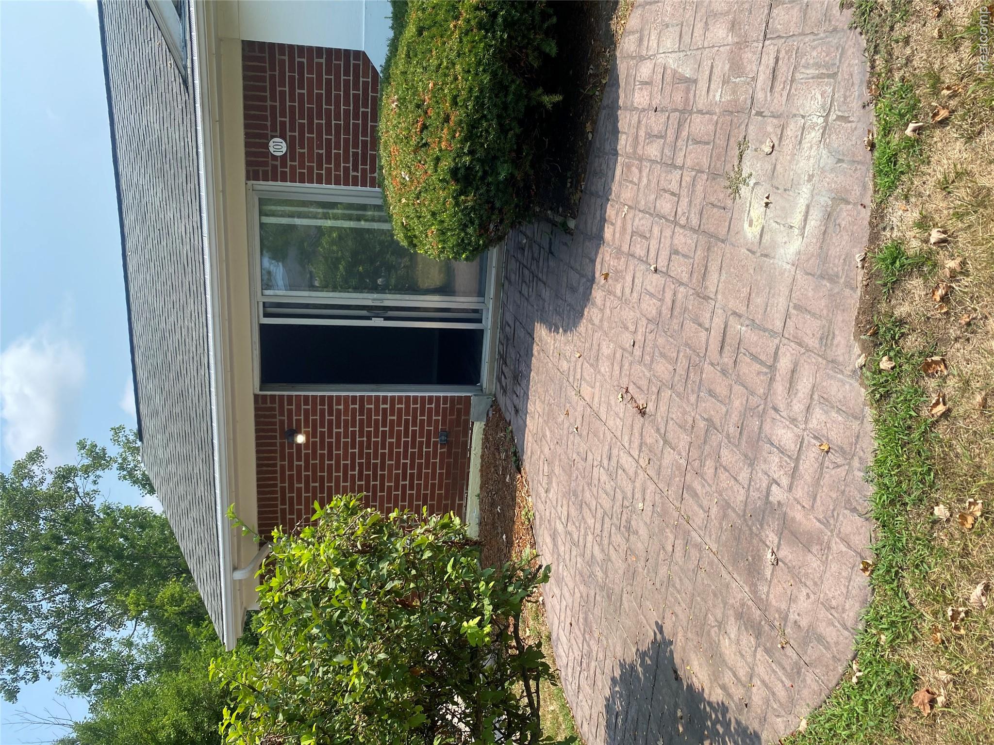 22000 Beck Road, Unit 101 Northville, MI 48167 - Photo 3 of 10 Brick exterior with a gray shingle roof and white gutters