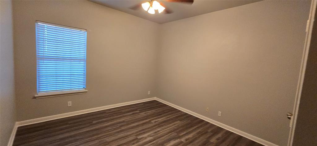 2616 South 2nd Street Waco, TX 76706 - Photo 12 of 29 Wood-finish flooring, neutral wall tones, window with horizontal blinds, and a ceiling fan with integrated lighting