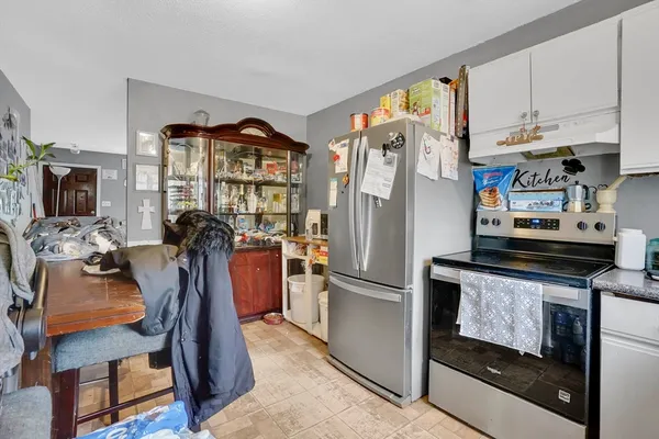 a kitchen with stainless steel appliances granite countertop a refrigerator a stove and a sink