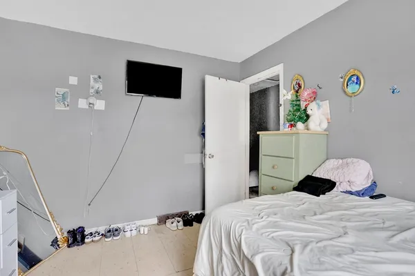 a bedroom with a bed and a flat tv screen on the dresser