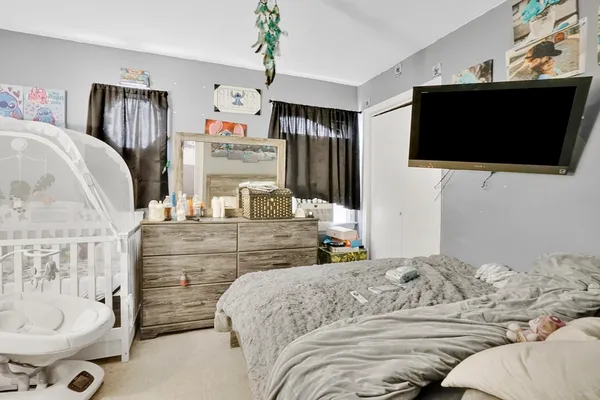 a bedroom with a bed and flat screen tv