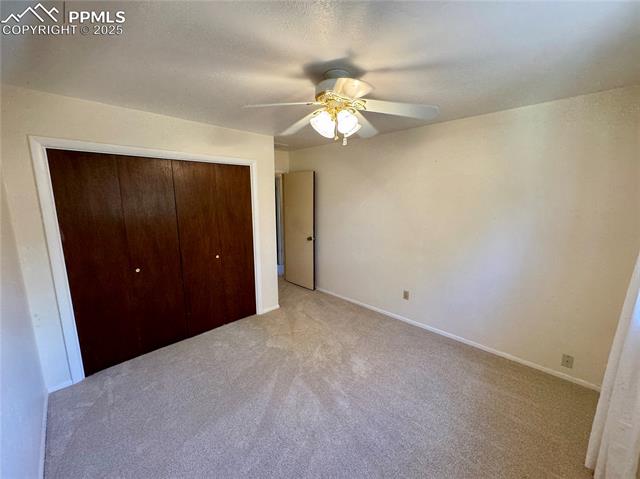 280 Raven Hills Road Colorado Springs, CO 80919 - Photo 33 of 48 Unfurnished bedroom with baseboards, a ceiling fan, a closet, and light colored carpet