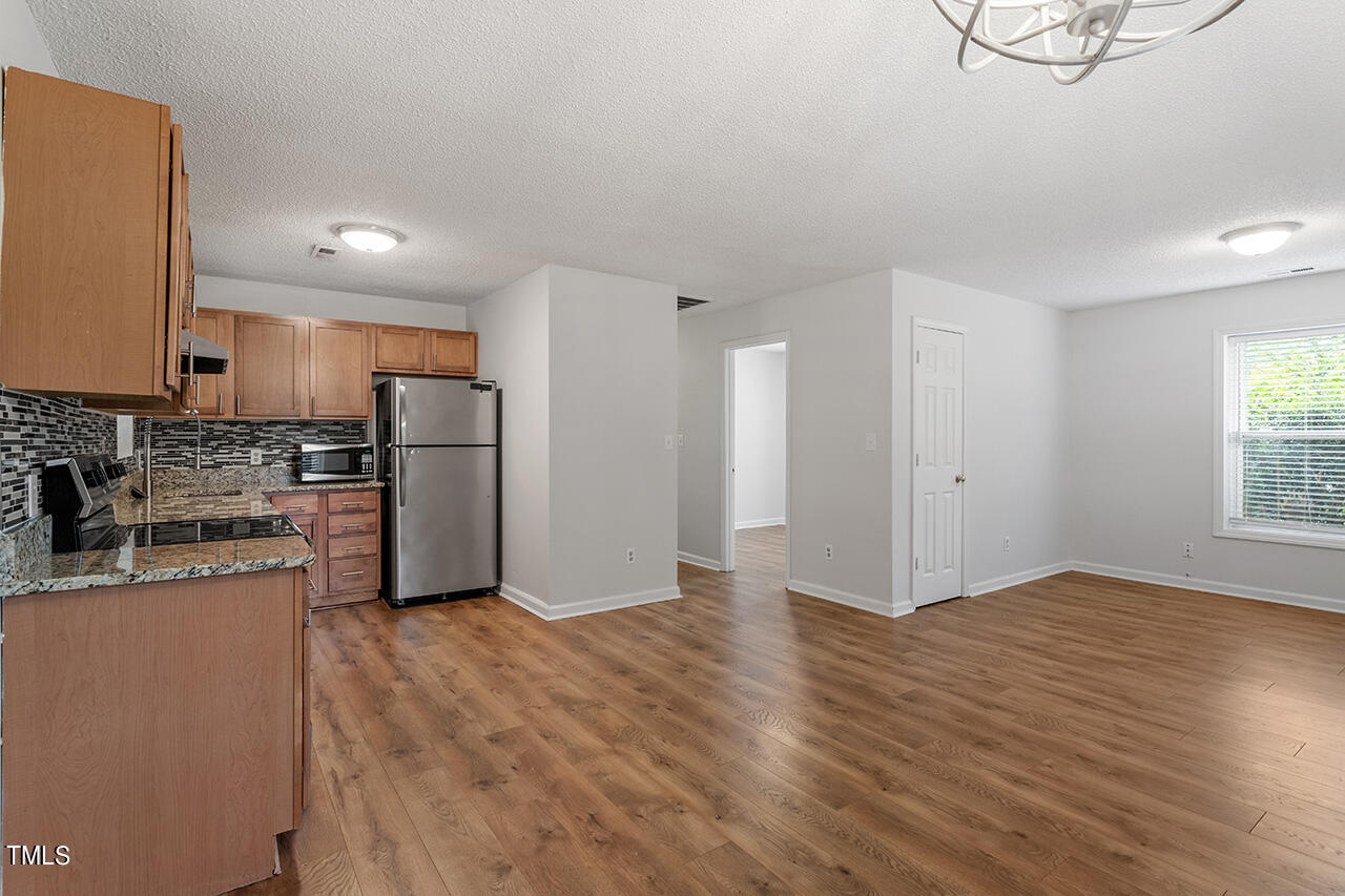 211 Golf Course Drive Raleigh, NC 27610 - Photo 7 of 14 a view of a kitchen with refrigerator and wooden floor