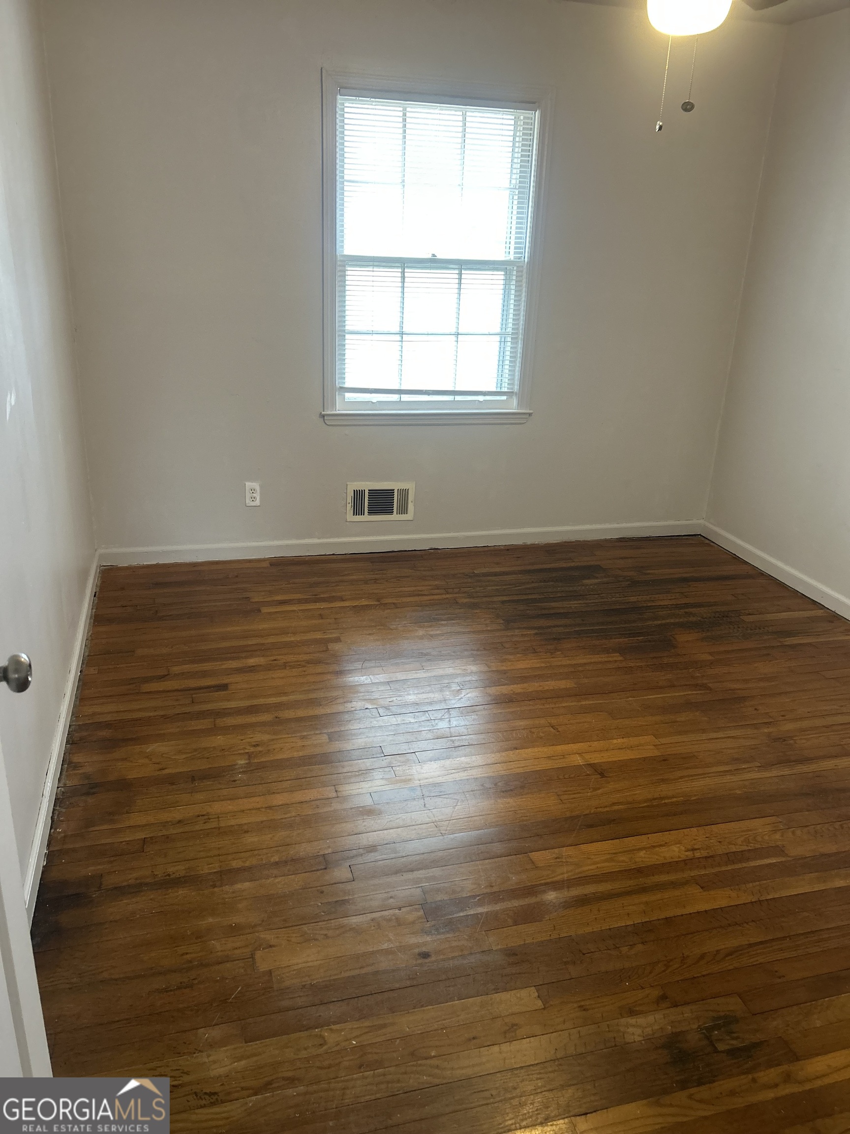 1406 Canterbury Road Griffin, GA 30223 - Photo 19 of 26 an empty room with wooden floor and windows