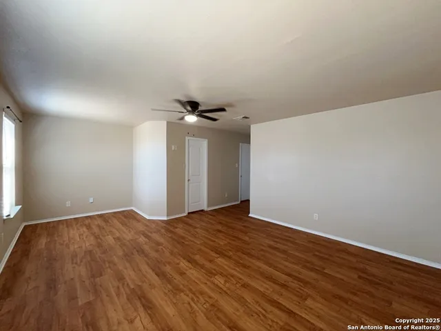 a view of an empty room with wooden floor