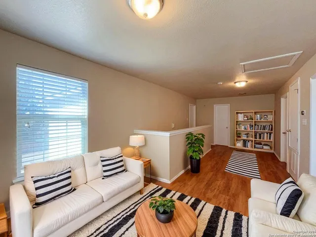 a living room with furniture and a wooden floor
